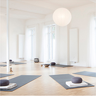 weisses Yogastudio mit Yogamatten in grau